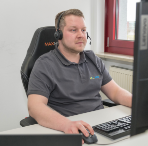 NEXTWERK IT-Support: Mitarbeiter mit Headset am Arbeitsplatz